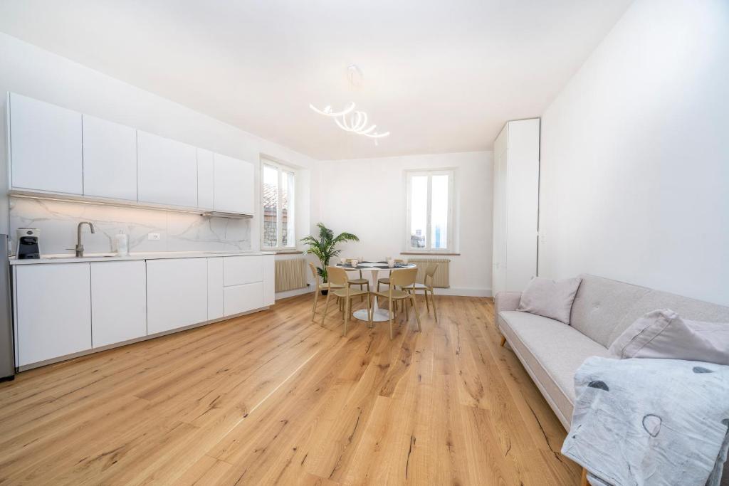 a white living room with a couch and a table at Cividale Medieval Town Apartment in Cividale del Friuli