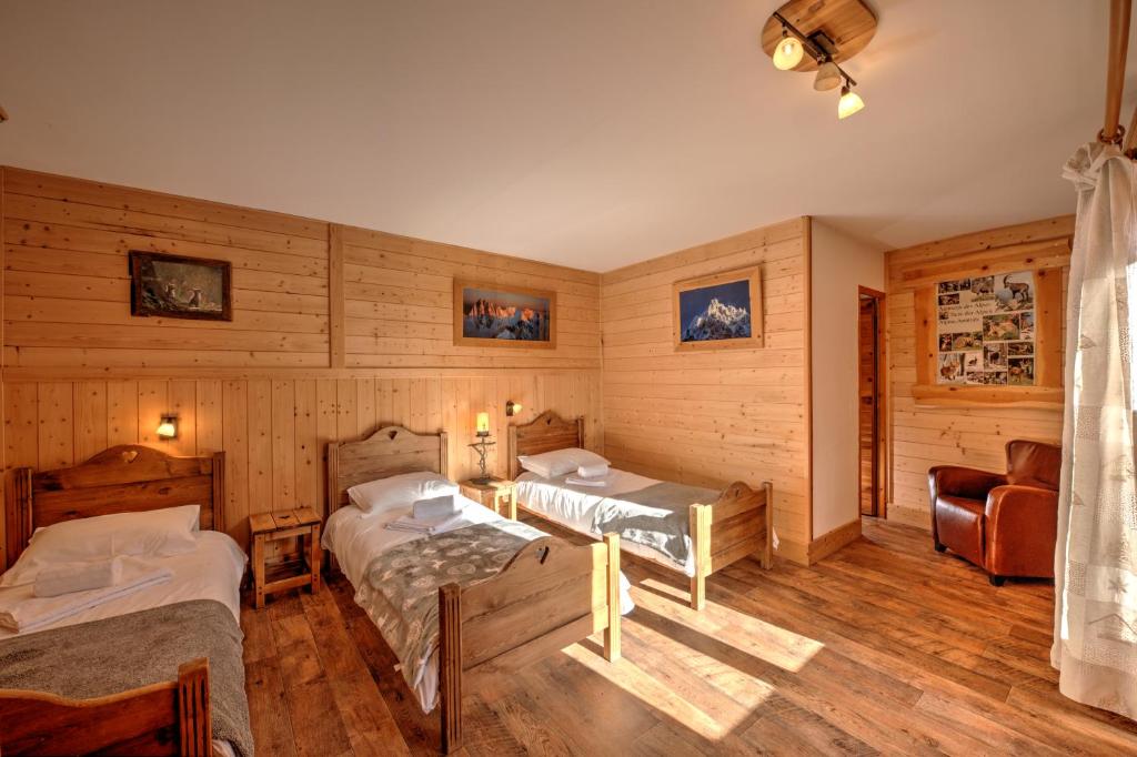 a room with two beds and a chair in it at Chalet MontBlanc in La Plagne Tarentaise