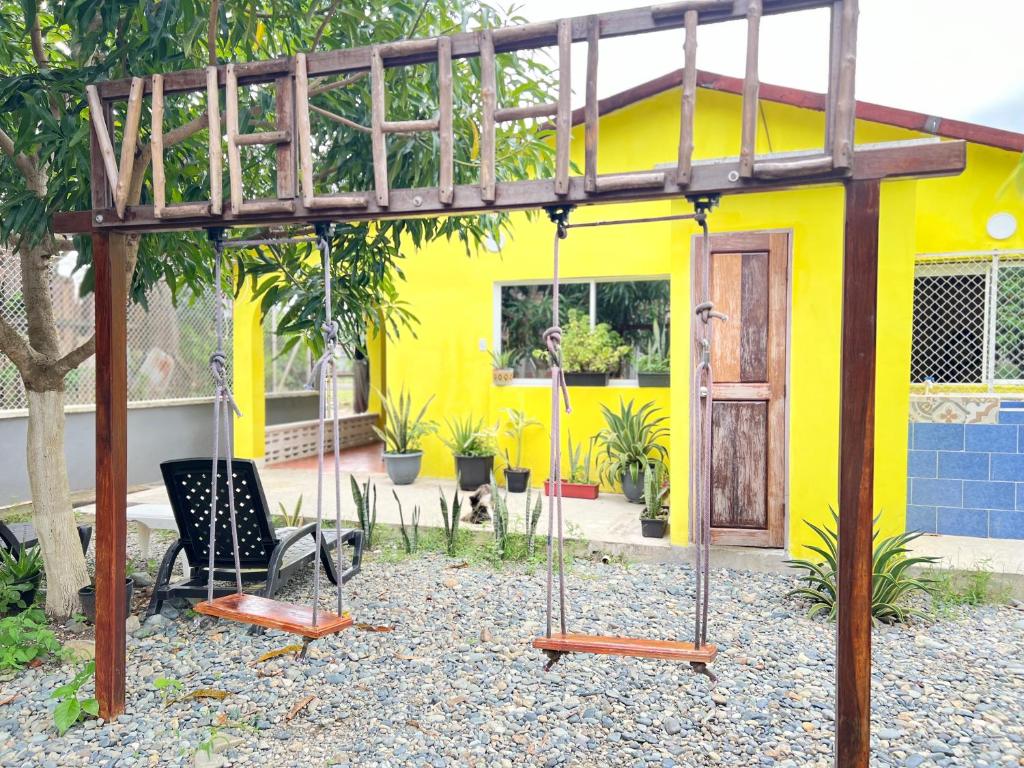 a swing set in front of a yellow house at Casa Manglares Capurganá in Acanti