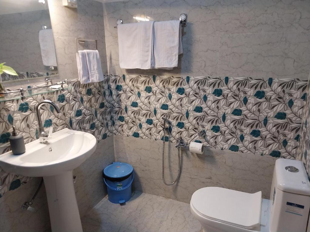a bathroom with a sink and a toilet and a shower at Bononi in Jorhāt