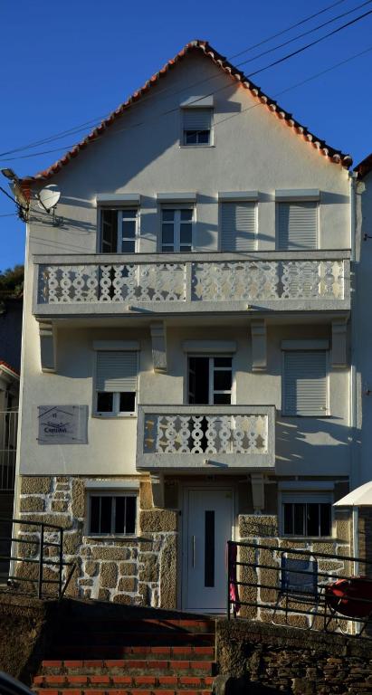 a white building with a balcony on the side of it at Casa da Ti Cristina in Pomares