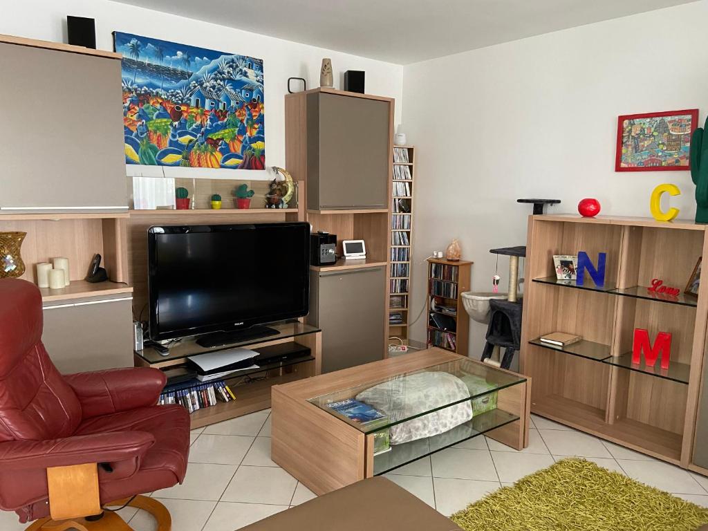 BriatexteにあるVilla moderne dans village typiqueのリビングルーム(テレビ、赤い椅子付)