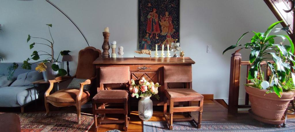 a living room with a desk with chairs and a vase of flowers at PARIS AUTHENTIC HOUSE Entier 1920's villa Métro Line 7 For Groups in Paris