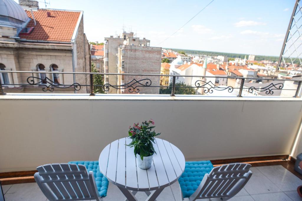 a table and chairs on a balcony with a view at Apartments Belvedere in Belgrade
