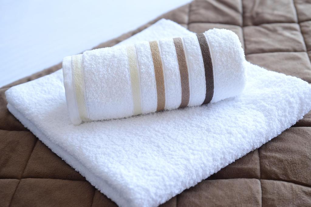 a stack of towels sitting on top of a bed at Apartments Belvedere in Belgrade