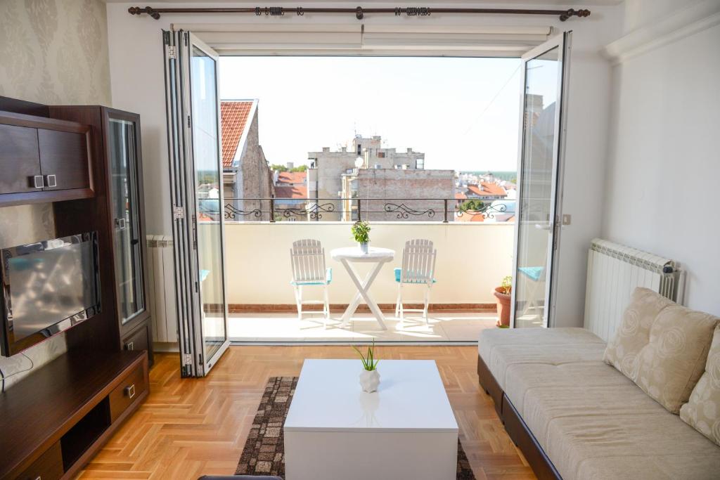 a living room with a couch and a view of a balcony at Apartments Belvedere in Belgrade