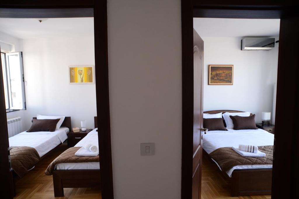 a room with two beds and a doorway with two beds at Apartments Belvedere in Belgrade
