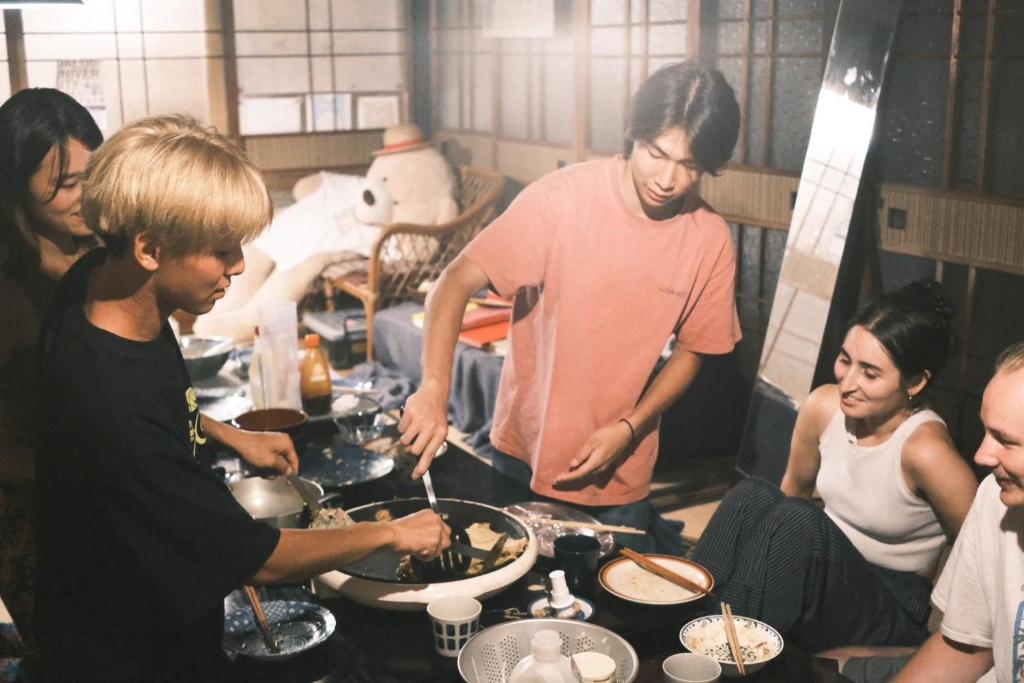a group of people standing around a table preparing food at Guesthouse SETOUCHI LIFE in Kure