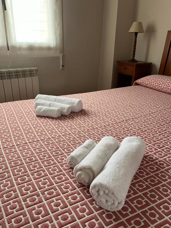 2 toallas encima de la cama en Santa Coloma Apartamentos, en Santa Coloma