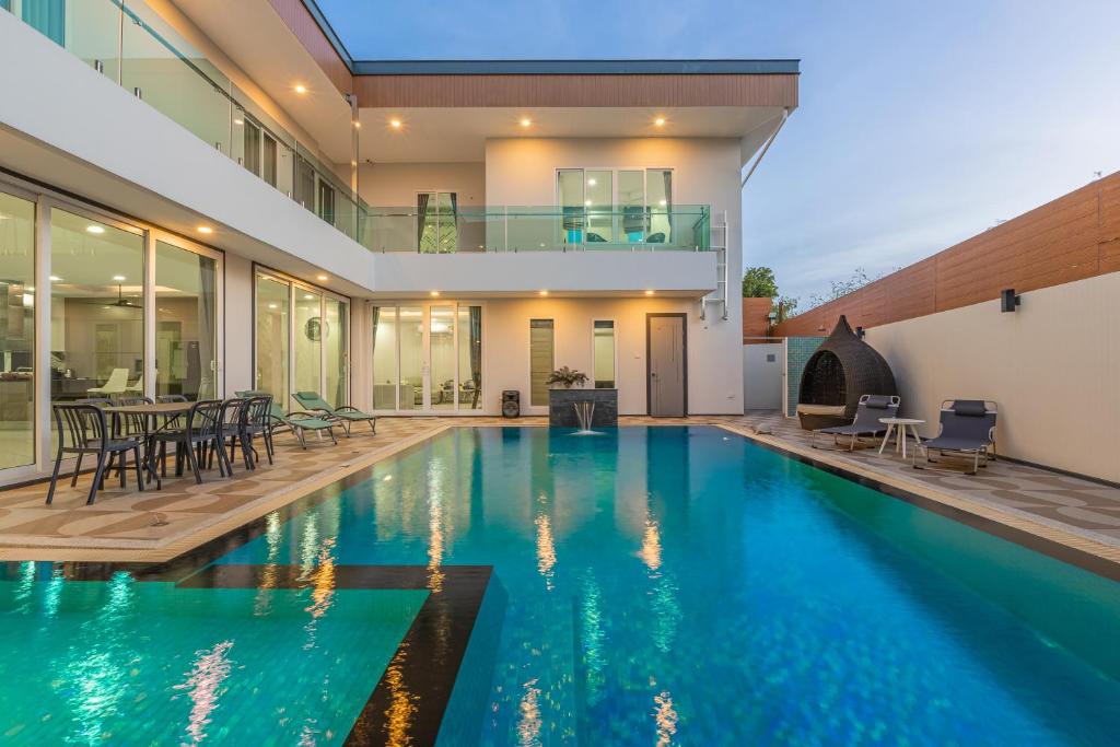 una piscina en el patio trasero de una casa en 芭提雅21航站楼附近8卧9卫轻奢现代别墅带独立歌房, en Norte de Pattaya