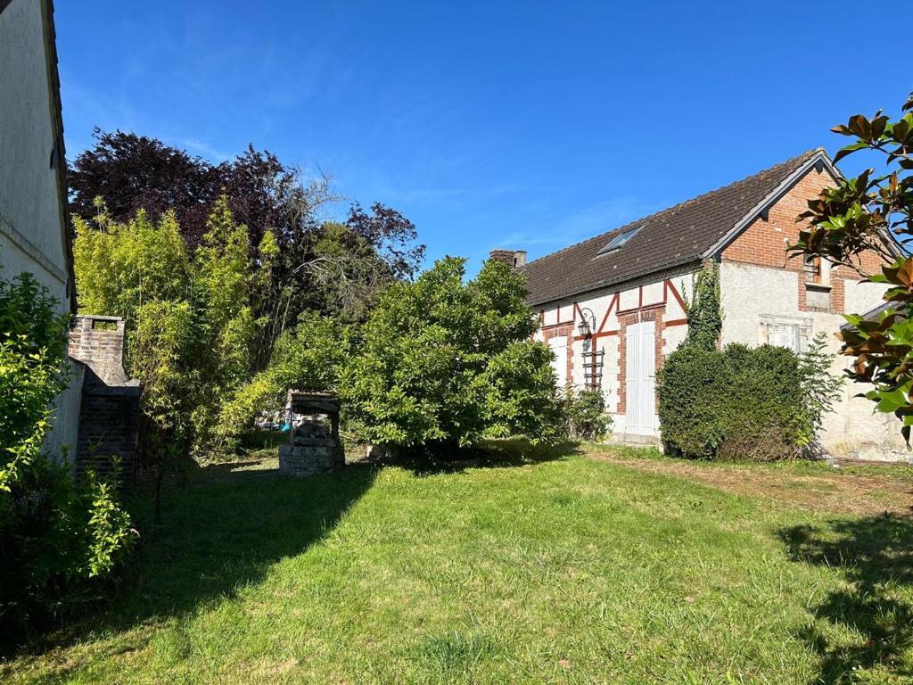ein Haus mit einem Hof mit Gras und Bäumen in der Unterkunft Maison de campagne familiale in LʼHabit