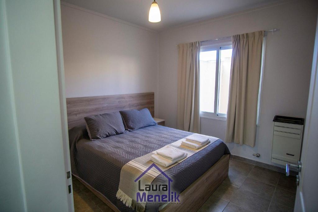 a bedroom with a bed with two towels on it at Luxury Arena in Viedma