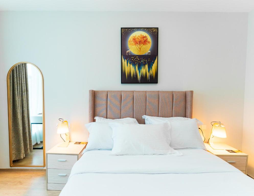 ein Schlafzimmer mit einem großen weißen Bett und einem Spiegel in der Unterkunft Elite Residences by Bednbeyond O72195O3I9 in Nairobi