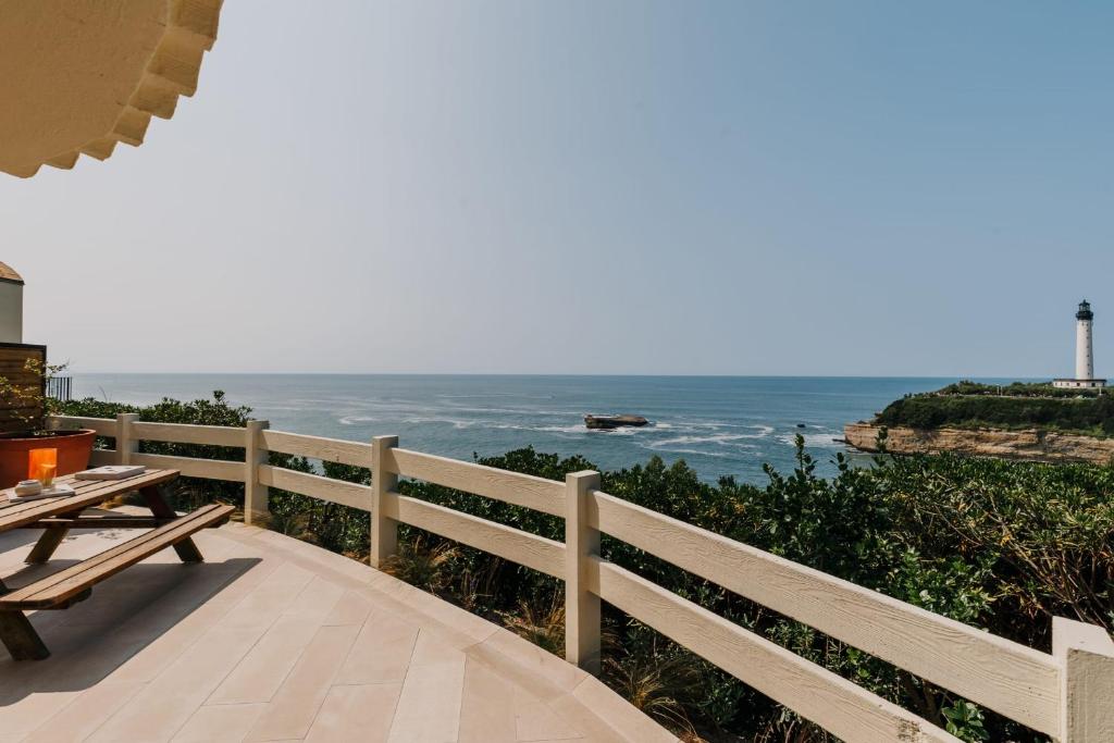 un balcon avec une table et une vue sur l'océan dans l'établissement Phare Ouest - Biarritz, à Biarritz