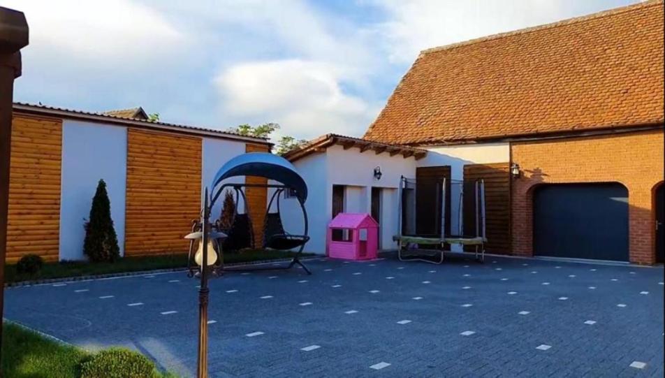 a house with a playground in the courtyard at Transilvania Guesthouse in Miercurea Sibiului