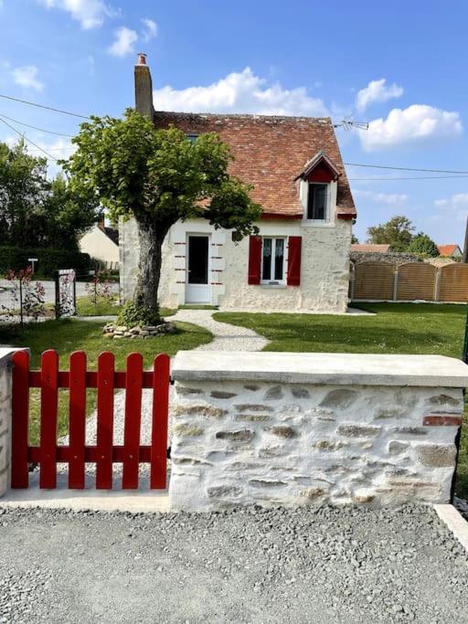 une clôture rouge devant une petite maison dans l'établissement La Petite Maison, à Villetrait