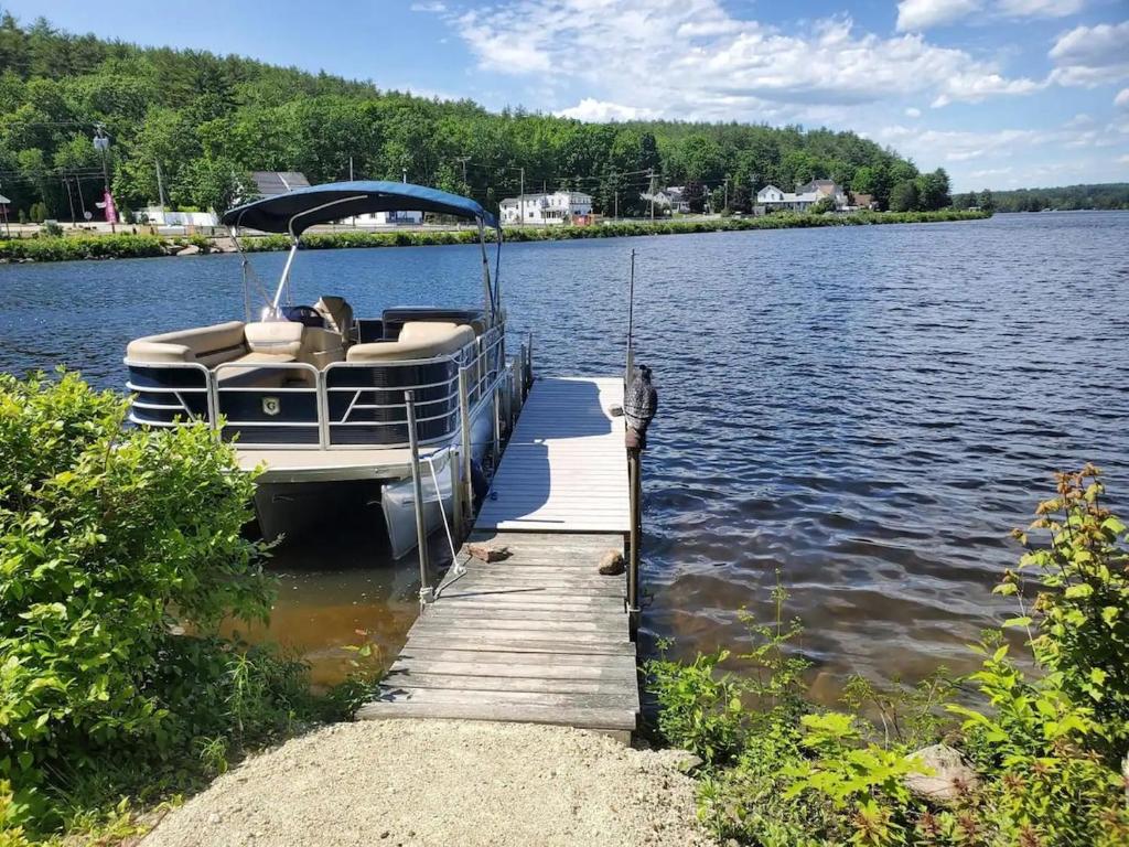 un barco estacionado junto a un muelle en un lago en Lakefront Home with Private Beach Access & Hot Tub, en Milton