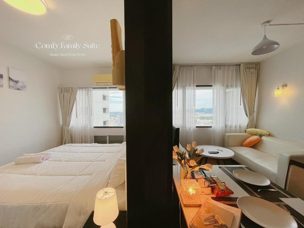 a bedroom with a bed and a living room at 2BR Comfy Family Suite Hat Yai in Hat Yai
