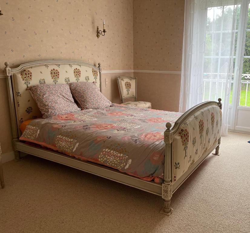 une chambre avec un lit dans une pièce avec une fenêtre dans l'établissement Maison de charme porte de Fécamp, à Saint-Léonard