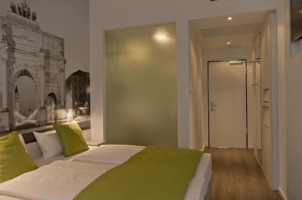 a bedroom with a bed with green and yellow pillows at Super 8 by Wyndham Munich City North in Munich