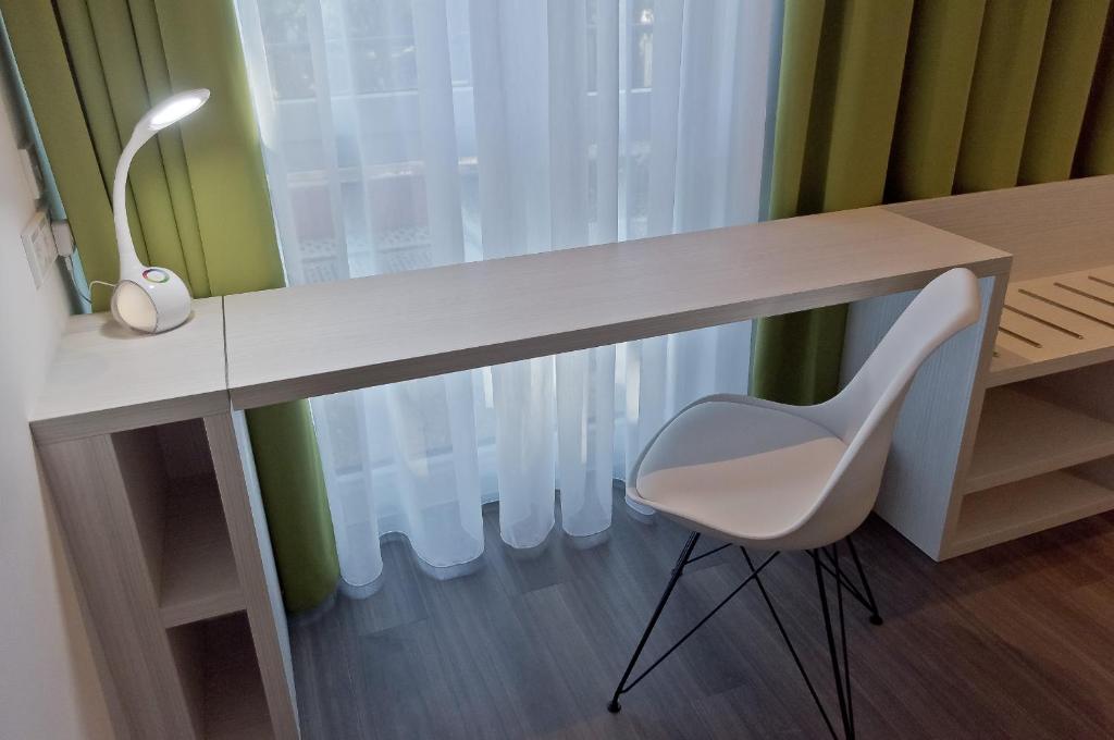 a white desk with a white chair next to a window at Super 8 by Wyndham Munich City North in Munich