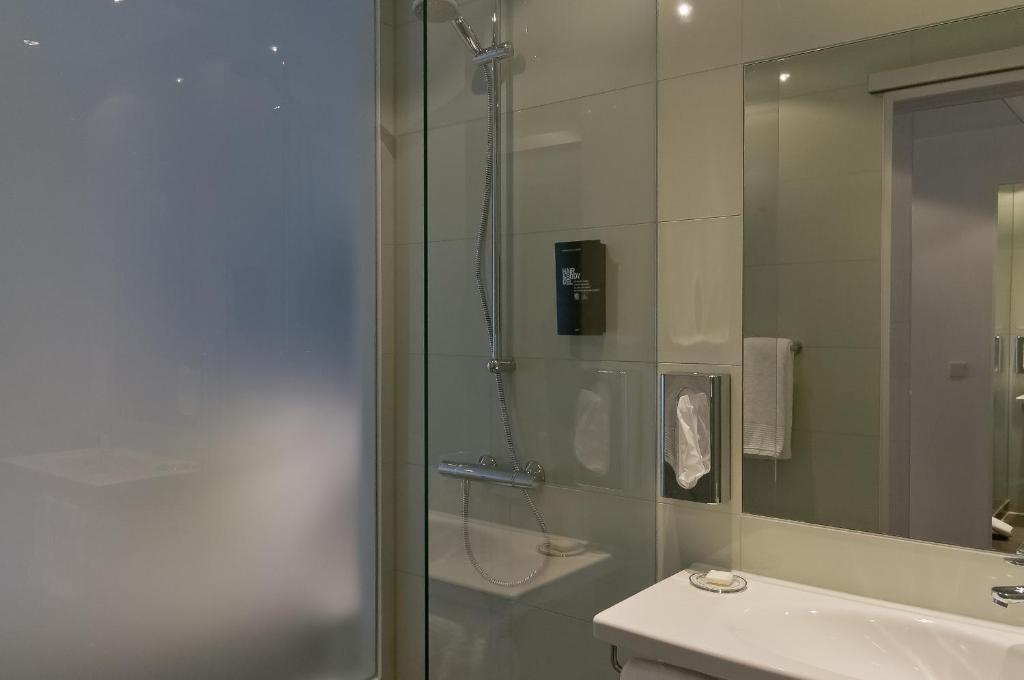 a bathroom with a shower and a toilet and a sink at Super 8 by Wyndham Munich City North in Munich