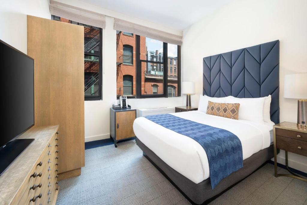 a hotel room with a bed and a flat screen tv at Hotel Indigo Boston Garden by IHG in Boston