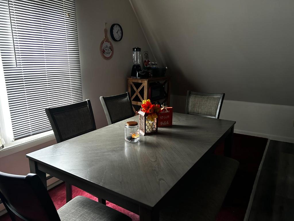 a dining room table with chairs and a table with flowers on it at Apartamento en Milwaukee cerca del centro 8 mins from Milwaukee downtown in Milwaukee