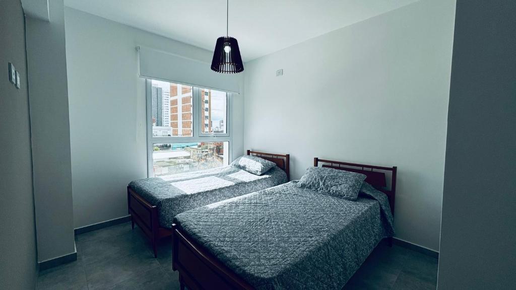 ein Schlafzimmer mit zwei Betten und einem Fenster in der Unterkunft Departamento Centro Santa Fe in Santa Fe