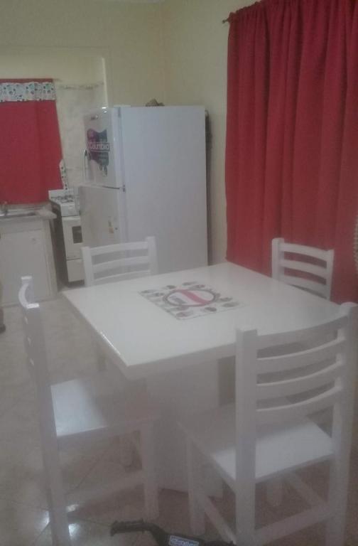 a white table and chairs in a kitchen with a refrigerator at Departamento Interno in Azul