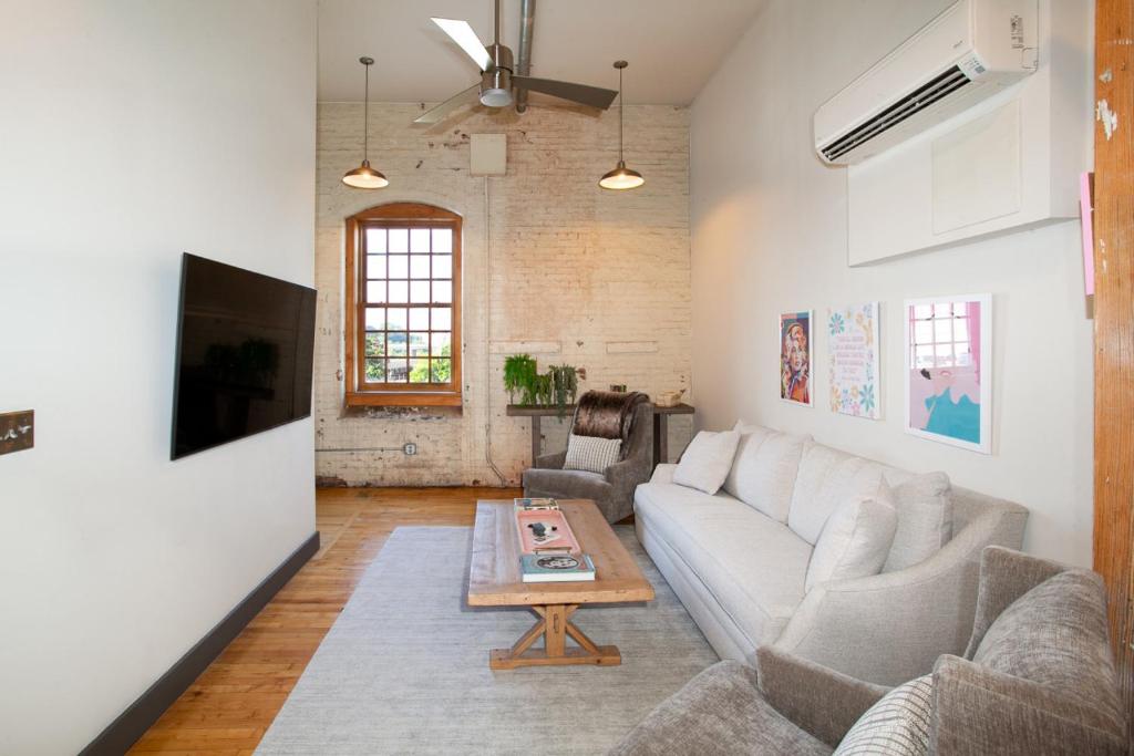 a living room with a couch and a table at Dollys Downtown Loft Knoxville in Knoxville