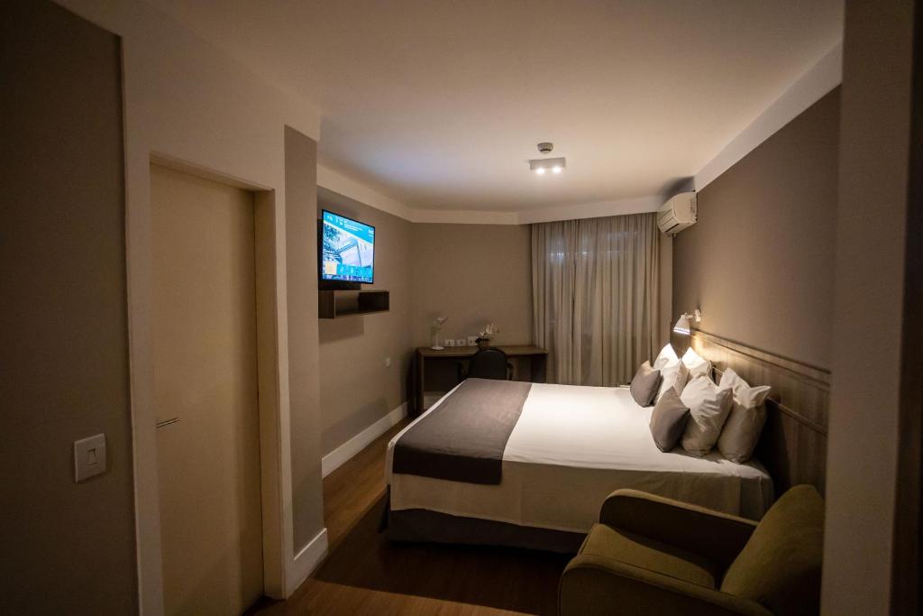 a hotel room with a bed and a tv at Hotel Trianon Paulista in Sao Paulo