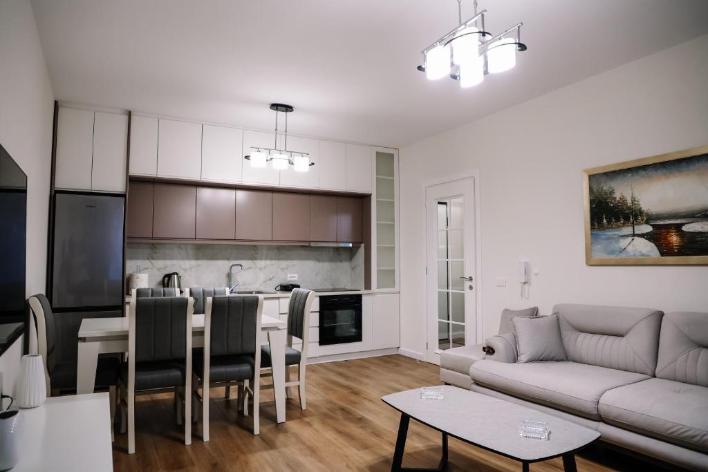 a living room and kitchen with a couch and a table at Oasis Apartment Korce in Korçë