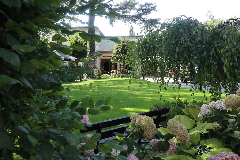 park z ławką na środku podwórza w obiekcie Willa Impresja Hotel i Restauracja w mieście Pabianice