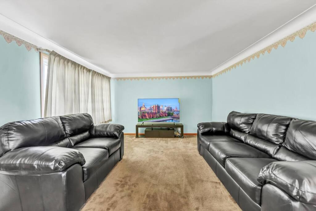 チークトワーガにあるNiagara Falls, Highmark, Buffalo Vacation Houseの革張りのソファとテレビのあるリビングルーム
