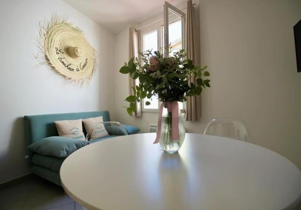 un vase de fleurs sur une table dans le salon dans l'établissement Au cœur de Cassis, à Cassis