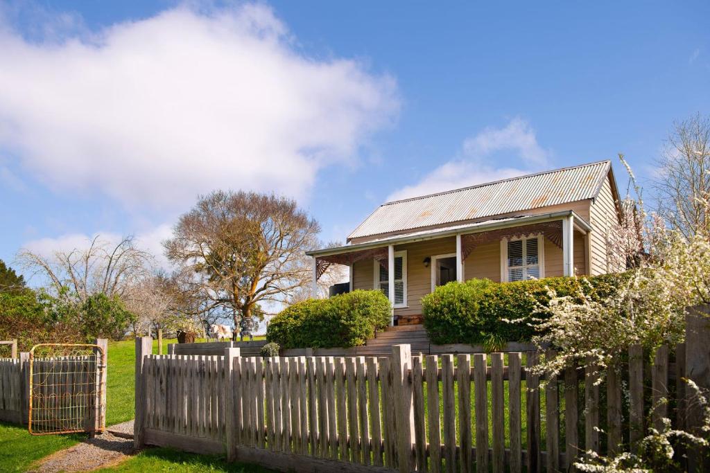 a house with a fence in front of it at Table Hill Cottage - dog friendly retreat in Daylesford