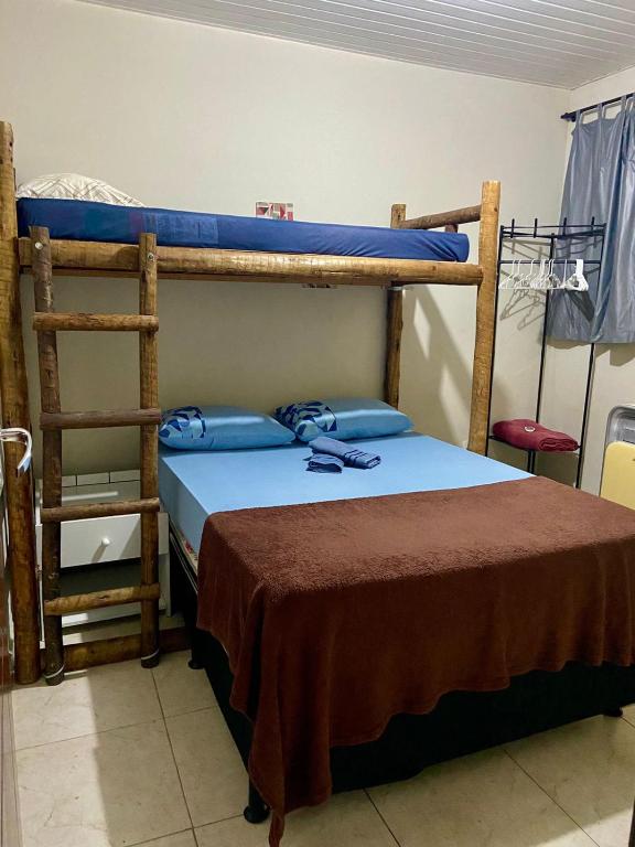 a bedroom with two bunk beds and a ladder at Casa top aeroporto in Macaé