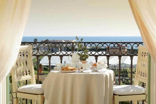 a table with a white table cloth on a balcony at Casa Raiola Ercolano Luxury Rooms & Spa in Ercolano