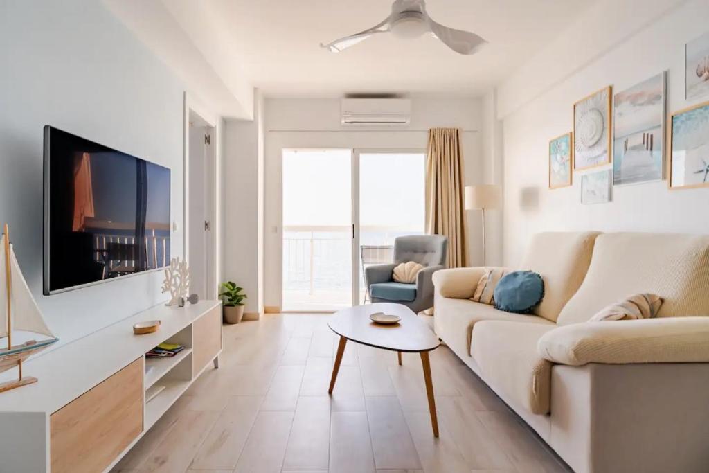 a white living room with a couch and a table at Siente el mar de la Vila in Villajoyosa