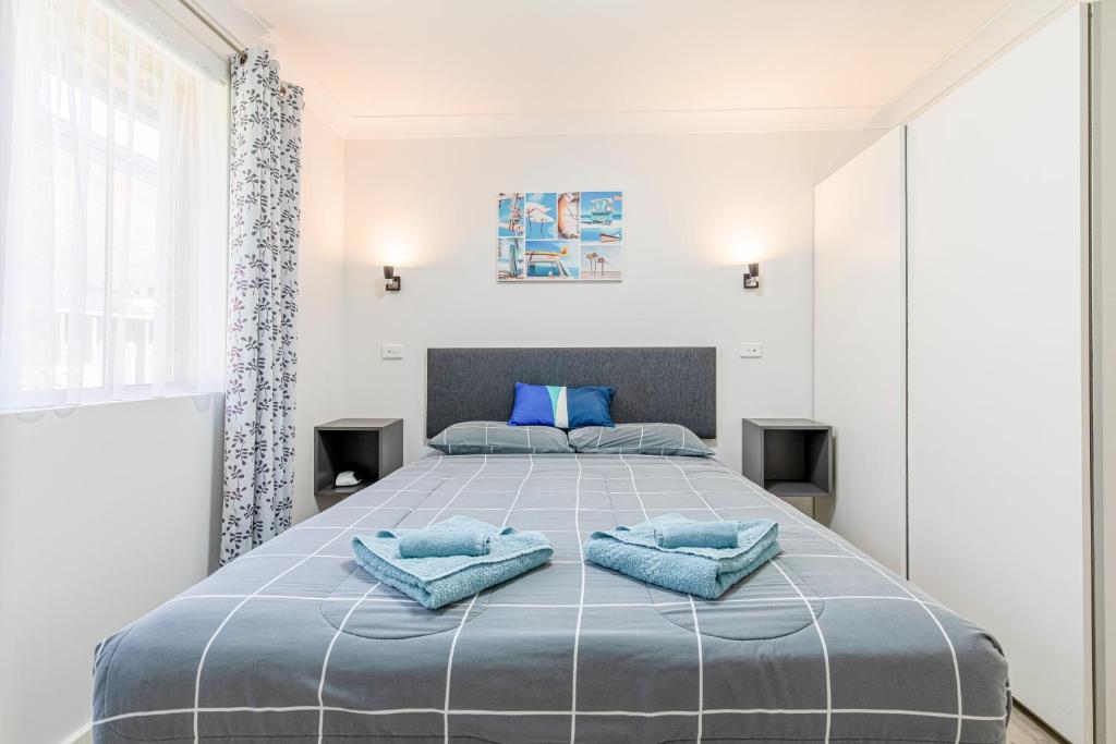 ein Schlafzimmer mit einem großen Bett mit blauen Kissen darauf in der Unterkunft Esperance Bay Holiday Park in Esperance