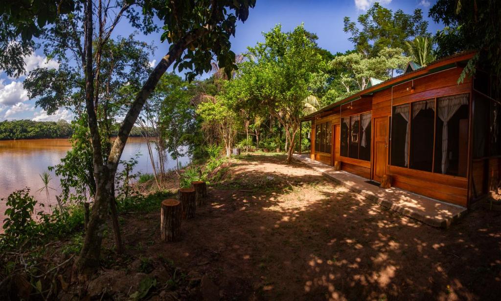 a cabin next to a body of water at Coco house tambopata in Puerto Maldonado