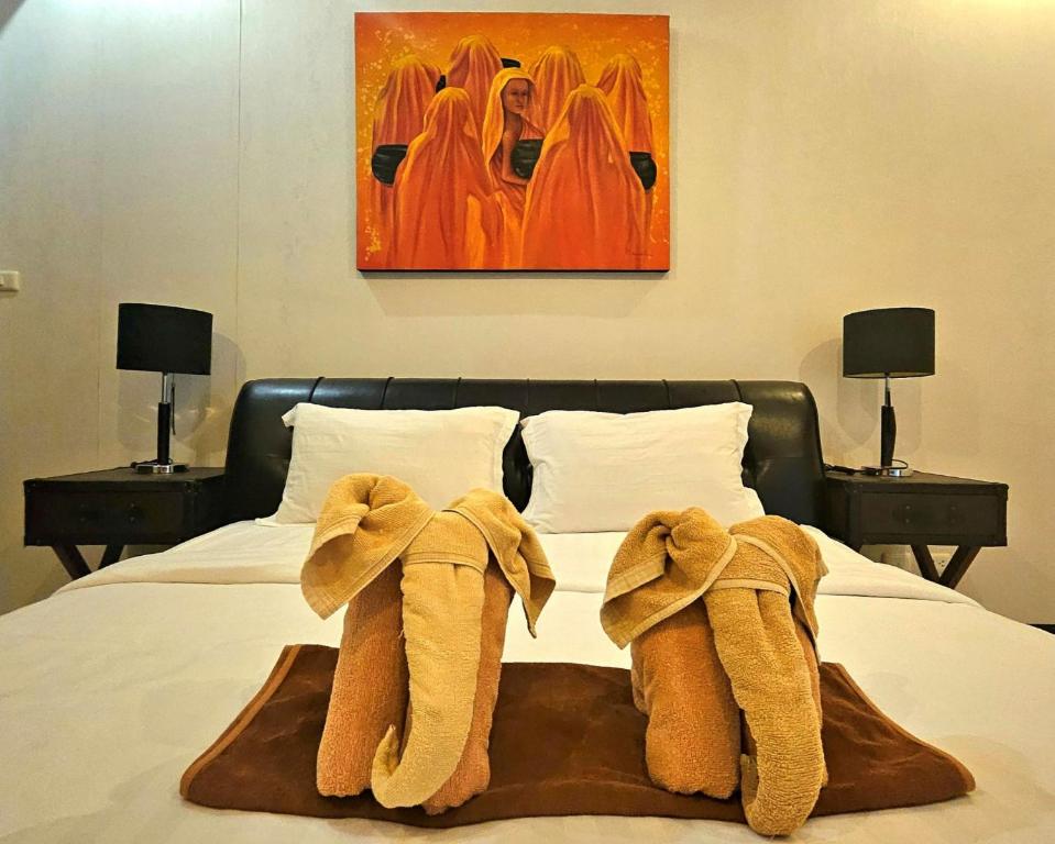 a bed with towels on top of it with two lamps at Апартаменты с видом на море на Карон Бич А 509 in Karon Beach