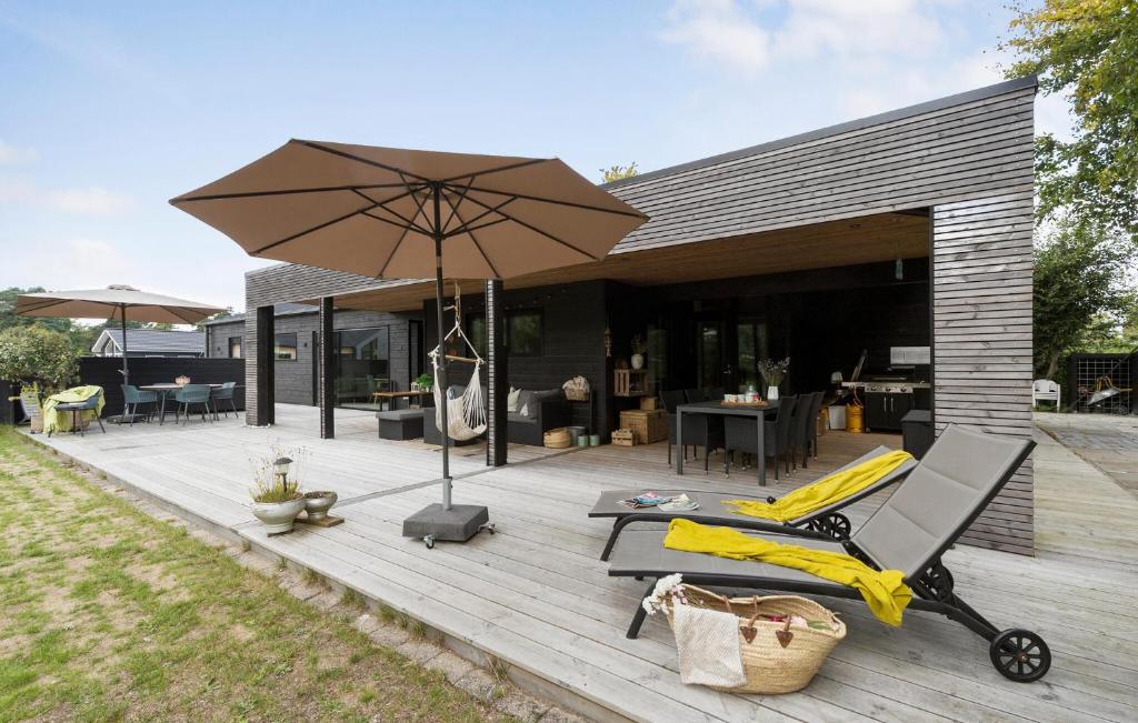 a patio with an umbrella and chairs and a table at 4 Bedroom Gorgeous Home In Glesborg in Glesborg