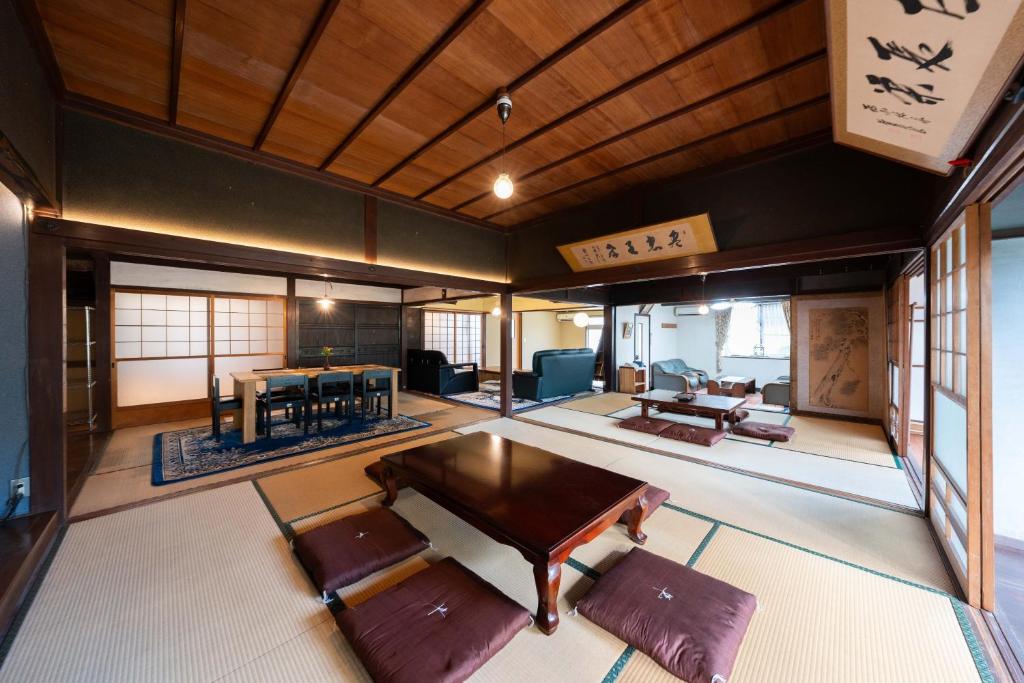 倉敷市にある倉敷の宿Retreat KOBAYASHI 1棟貸切 1日1組限定 11LLDDK 520平米 102年前の伝説の建物 瀬戸内芸術祭2025 直島 美観地区 最大10名 駐車場3台 ベッド8台のテーブルと椅子が備わる客室です。