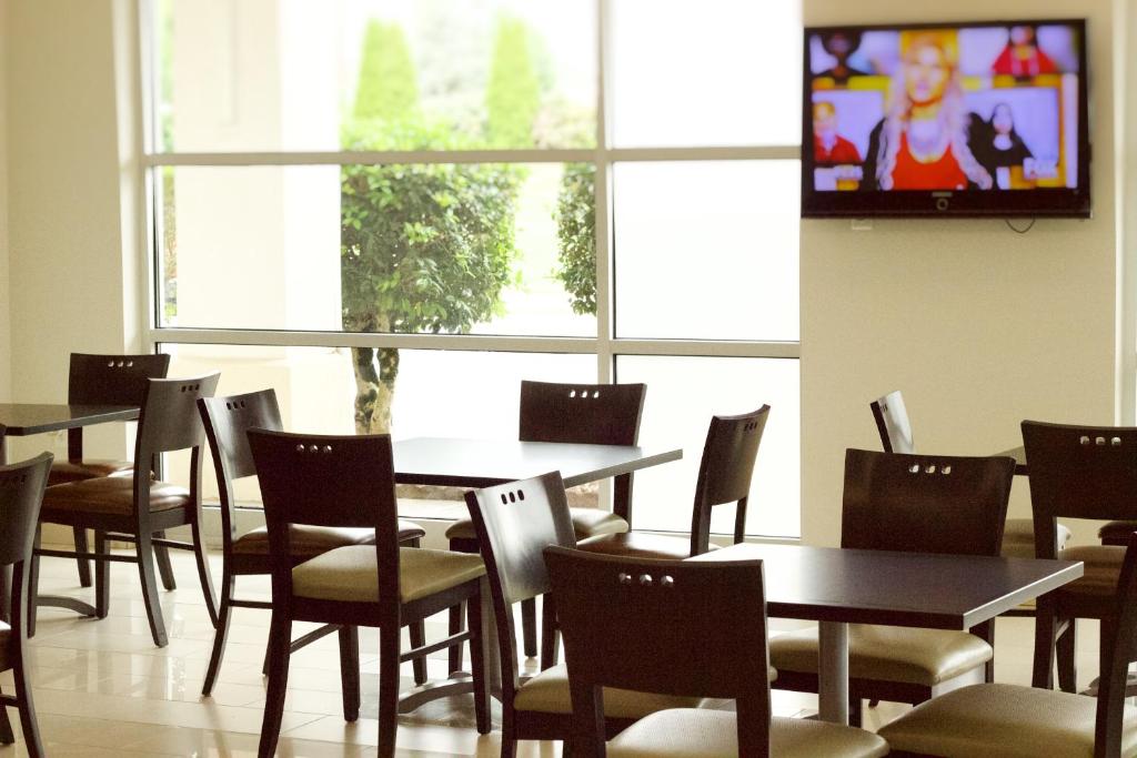 a dining room with tables and chairs and a tv at Quality Inn near Chattanooga South in Ringgold