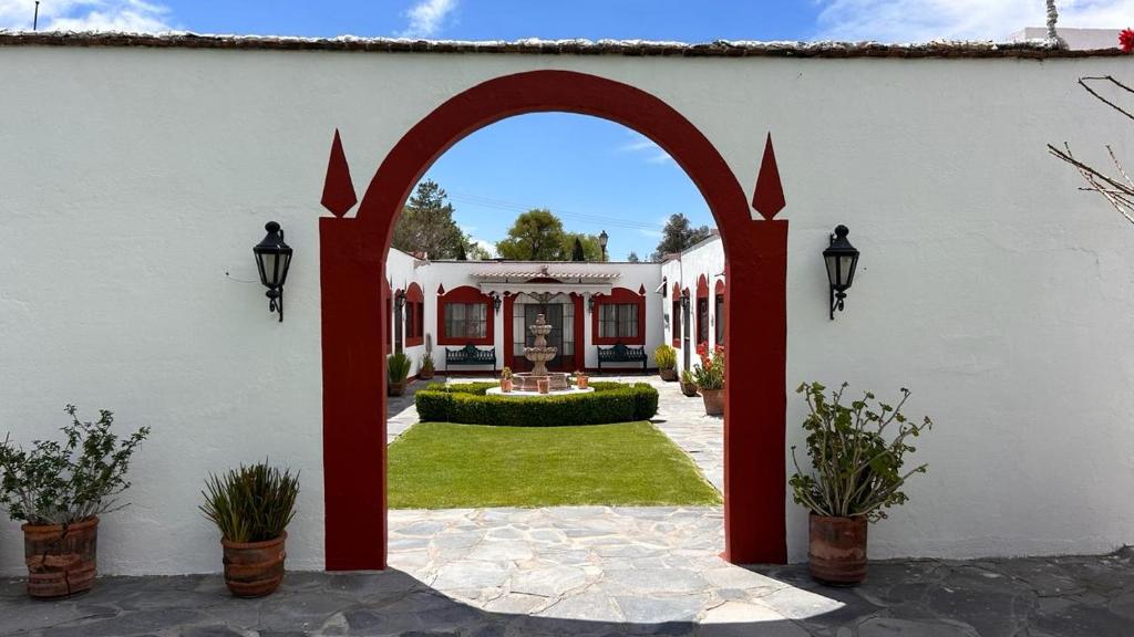 ein Torbogeneingang zu einem weißen Haus mit Garten in der Unterkunft Hacienda de Pueblito Atotonilco in Banda