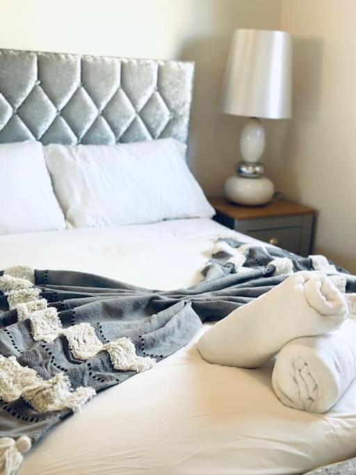 a bed with a blanket and a teddy bear on it at 2 Bed Entire Upper Cottage Flat in Central Glasgow in Glasgow
