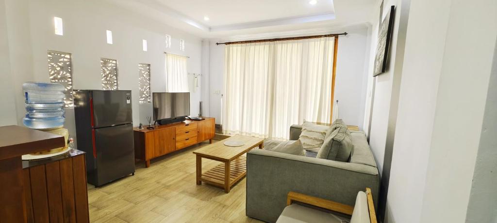 a living room with a couch and a refrigerator at Nyaman Villa Ubud in Ubud