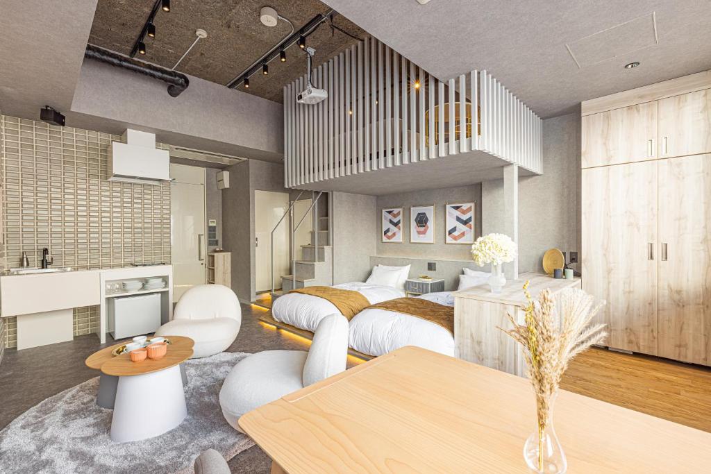 静岡市にあるビル泊 -Birupaku Decentralized Hotel-のベッドルーム1室(ベッド2台付)、ダイニングルームが備わります。